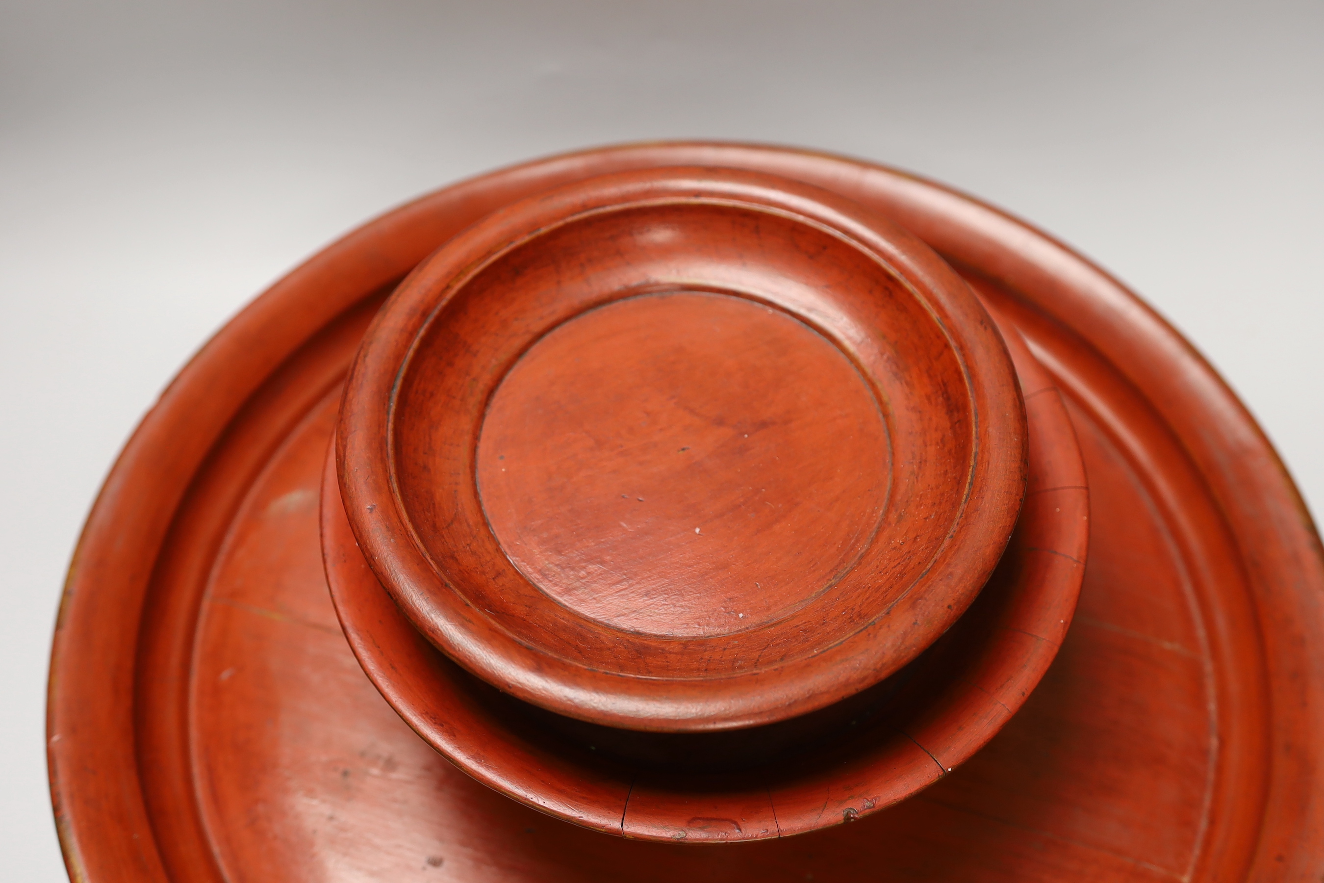 Three Burmese red lacquer dishes, largest 46cm